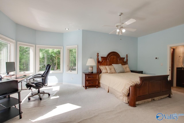 carpeted bedroom featuring multiple windows and ceiling fan