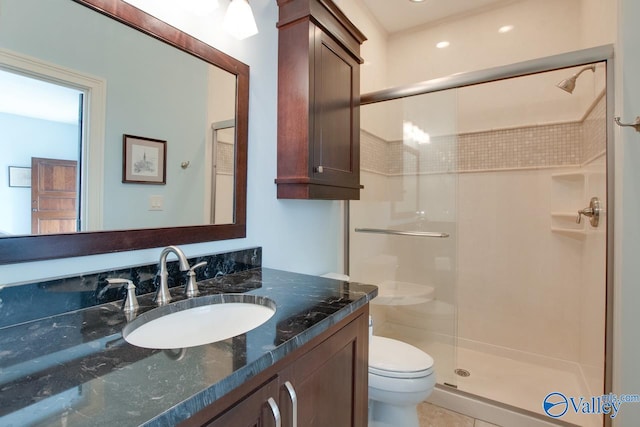 bathroom with walk in shower, tile patterned flooring, toilet, and vanity