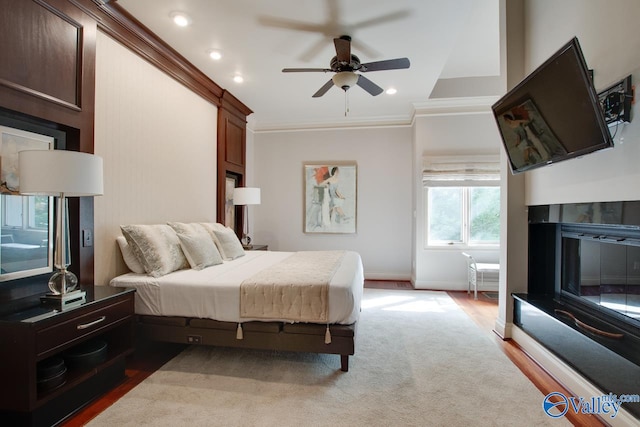 bedroom with ceiling fan, hardwood / wood-style flooring, and ornamental molding