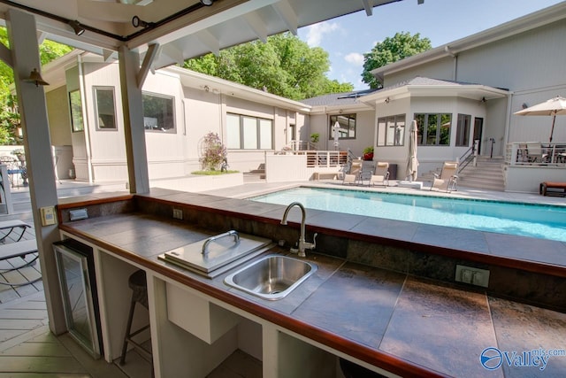 view of swimming pool featuring sink and a patio