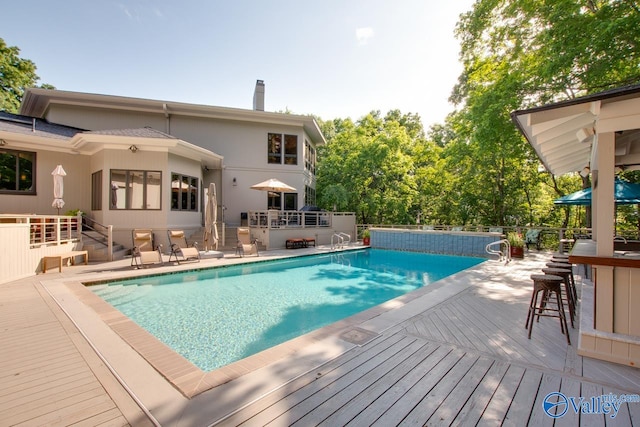 view of pool with a deck and an outdoor bar