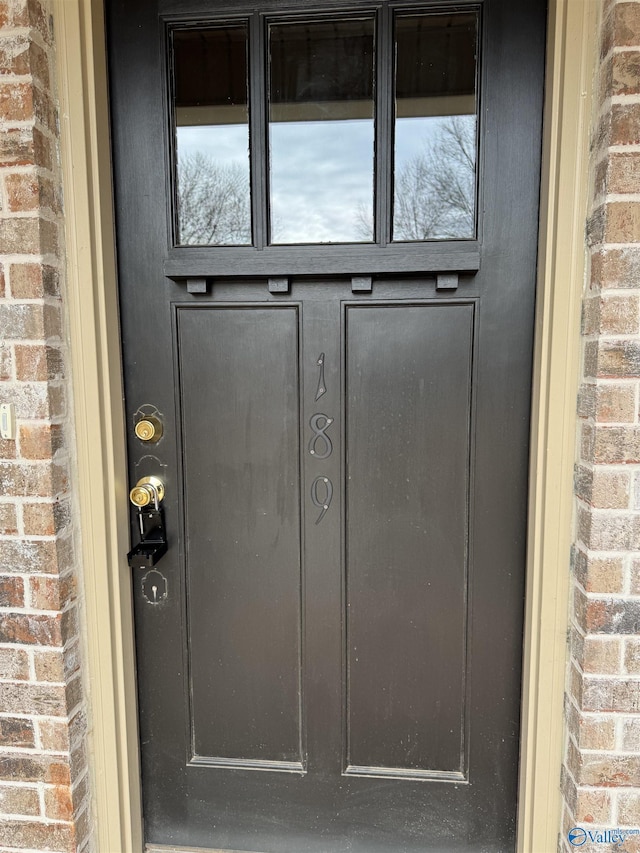 doorway to property featuring brick siding