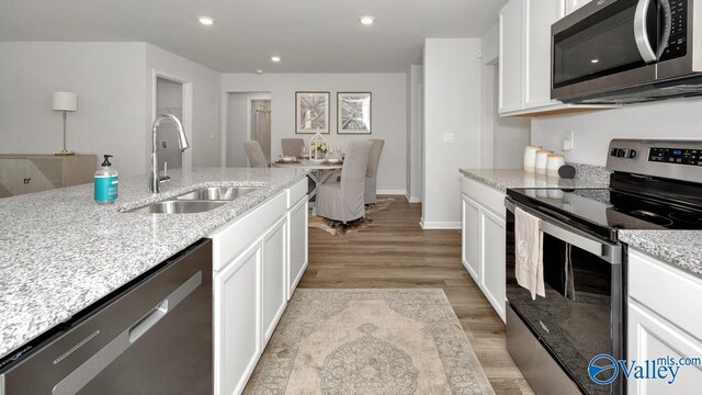403 Jackson Point Cir, Huntsville, AL 35811 - kitchen with stainless steel appliances, light wood-type flooring, white cabinetry, light stone counters, and recessed lighting