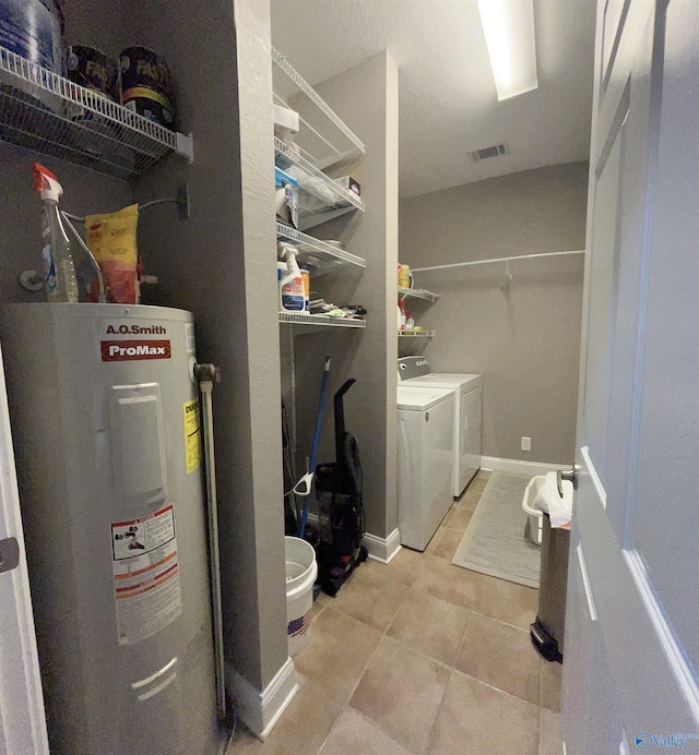 washroom featuring laundry area, visible vents, tile patterned floors, washing machine and clothes dryer, and water heater