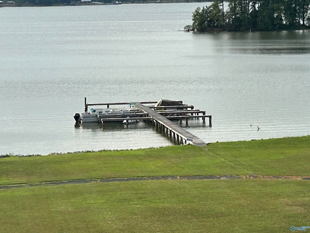 view of dock with a water view and a lawn