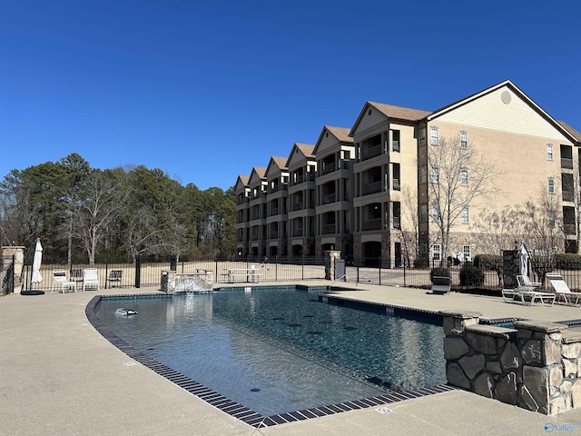 pool with a patio and fence