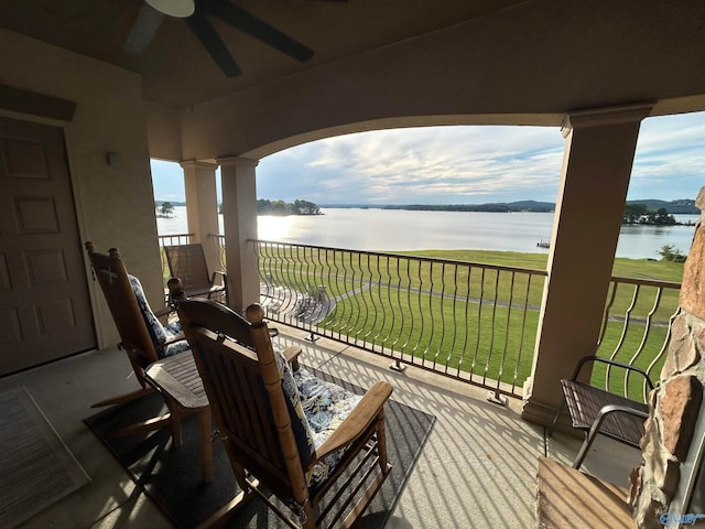 exterior space featuring ceiling fan, a yard, and a water view