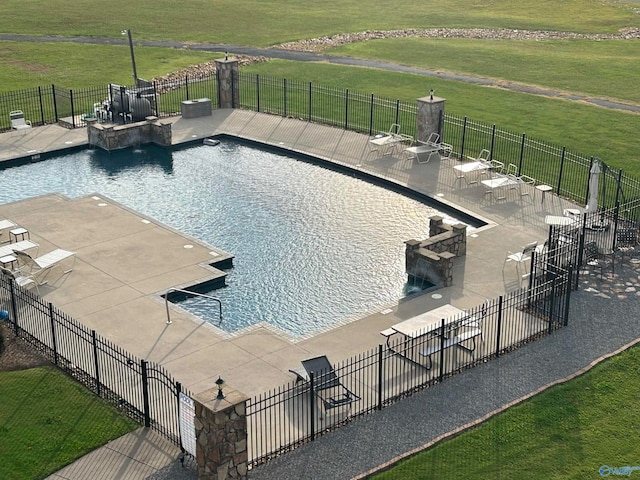 view of swimming pool featuring a patio area and a lawn