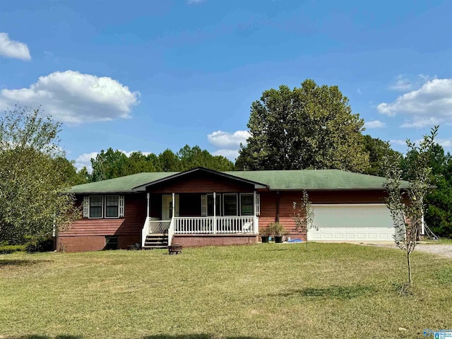 view of front of property with covered porch, a garage, and a front lawn