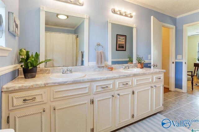 bathroom with a textured ceiling, vanity, crown molding, and hardwood / wood-style flooring