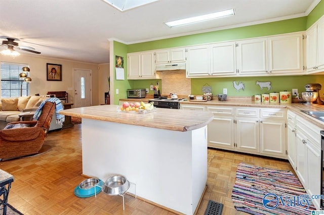 kitchen featuring ornamental molding, light parquet flooring, white cabinetry, and a healthy amount of sunlight