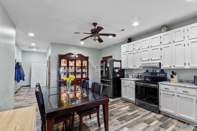kitchen with light wood-style floors, visible vents, black fridge with ice dispenser, and electric range