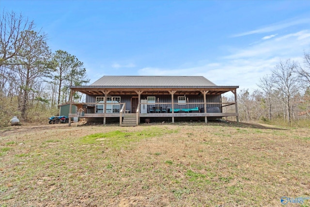 view of front of home with metal roof and a front lawn