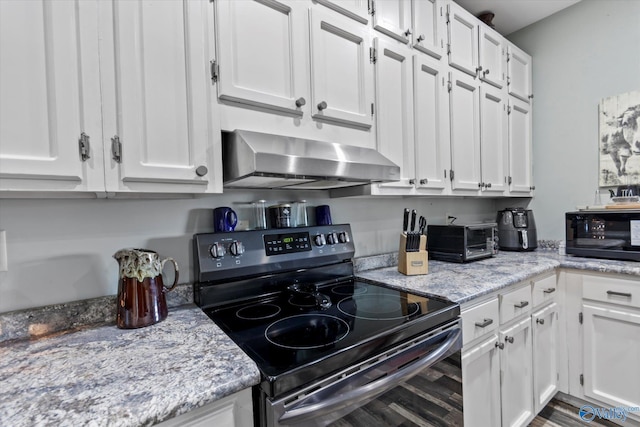 kitchen with white cabinetry, wall chimney range hood, and black appliances