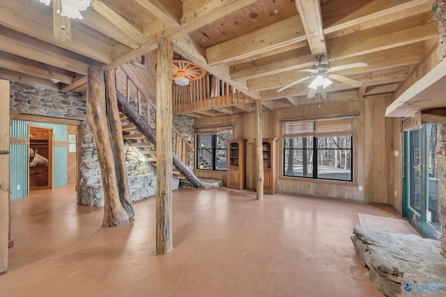 136 Higdon Rd, Falkville, AL 35622 - unfurnished living room featuring a ceiling fan, finished concrete flooring, stairs, and wooden walls