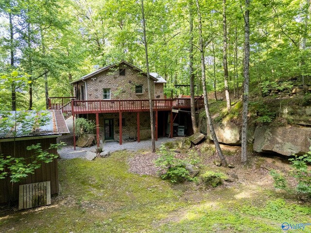 136 Higdon Rd, Falkville, AL 35622 - rear view of property featuring a deck, brick siding, and a forest view