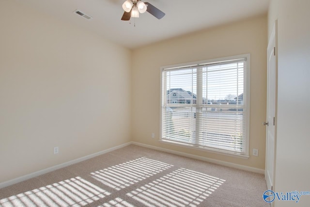 carpeted spare room with ceiling fan