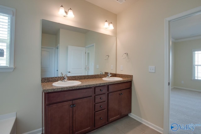 bathroom with tile patterned flooring, vanity, crown molding, and a wealth of natural light