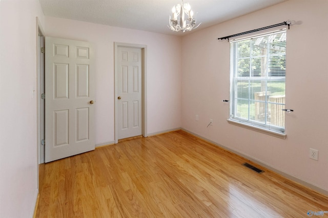209 Leslie Ln, Harvest, AL 35749 - unfurnished bedroom featuring a chandelier and light wood-type flooring