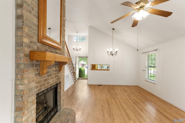 209 Leslie Ln, Harvest, AL 35749 - unfurnished living room with a chandelier, light wood finished floors, a fireplace, a ceiling fan, and high vaulted ceiling