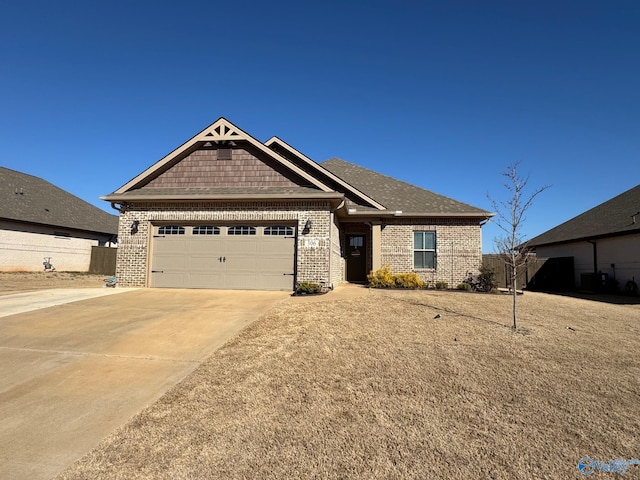 craftsman house featuring concrete driveway, an attached garage, fence, and brick siding