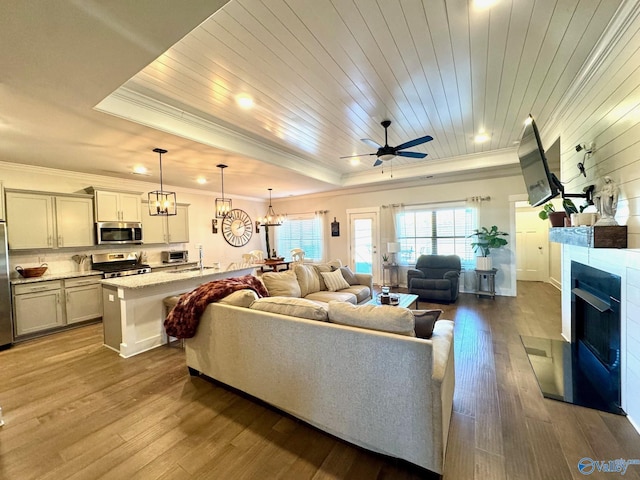 living area with wooden ceiling, a fireplace, crown molding, and wood finished floors