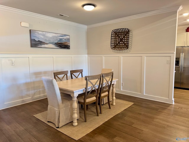 dining space with visible vents, ornamental molding, dark wood-style flooring, and a decorative wall