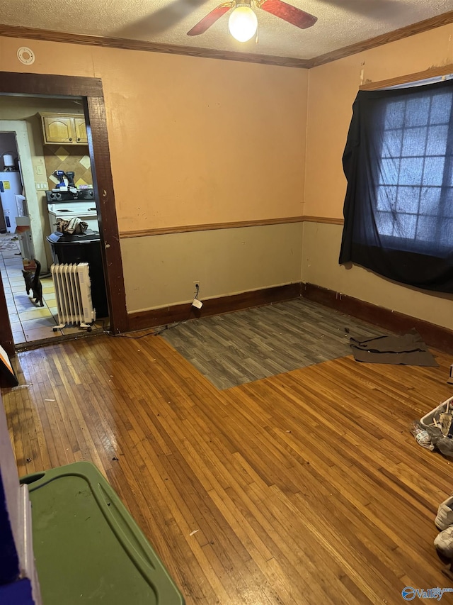 empty room with crown molding, wood-type flooring, and a textured ceiling