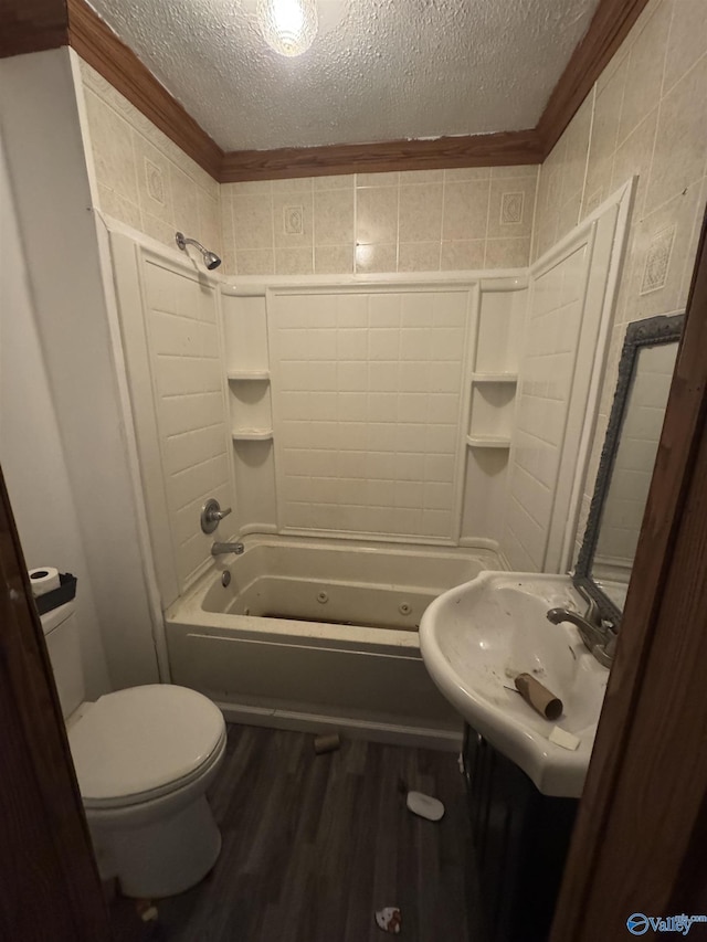 full bathroom with sink, wood-type flooring, a textured ceiling, shower / washtub combination, and toilet