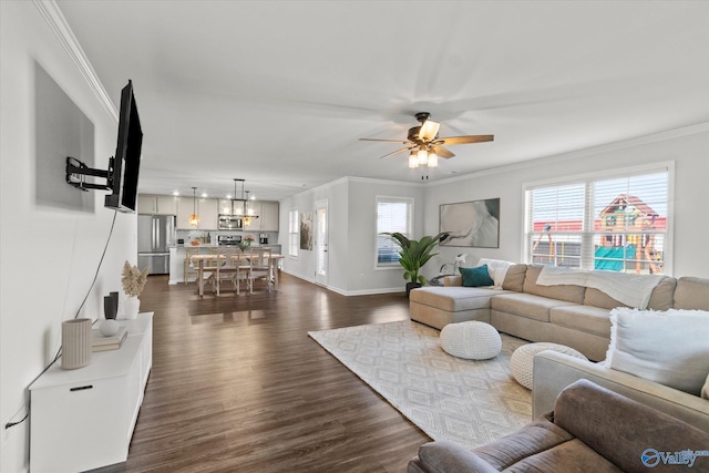 living room with plenty of natural light, ceiling fan, ornamental molding, and dark wood-type flooring