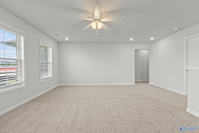 carpeted spare room featuring ceiling fan