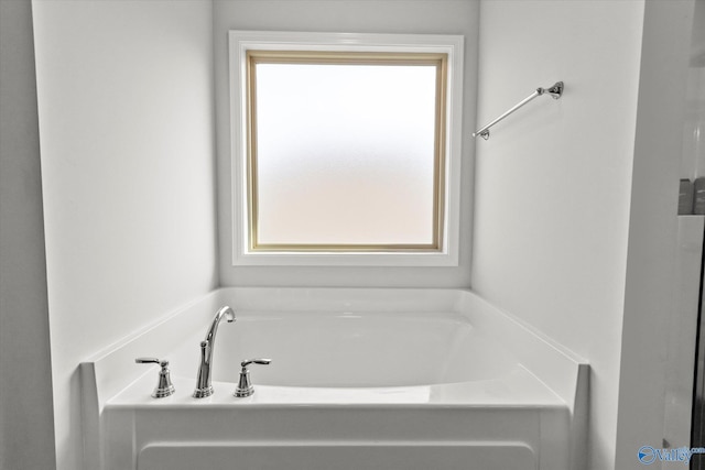 bathroom with a tub to relax in and plenty of natural light