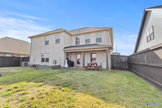 back of house with a patio area, a lawn, and central air condition unit