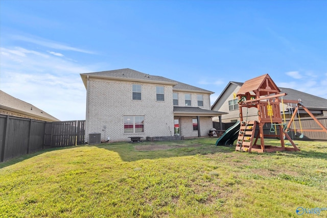 rear view of house featuring a playground, a yard, and central air condition unit