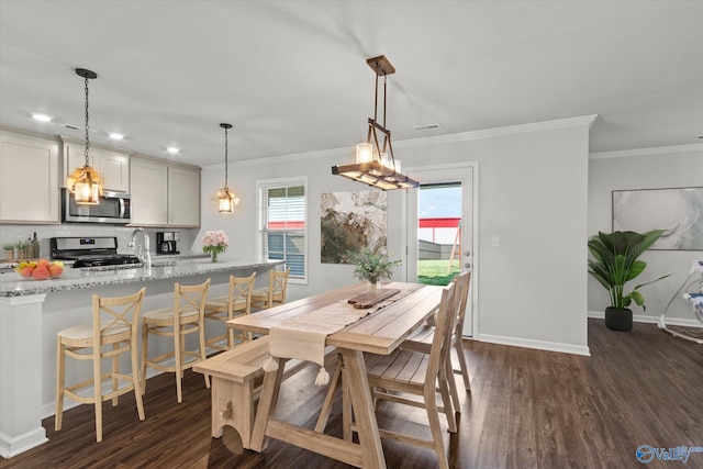 dining space featuring ornamental molding, dark wood-type flooring, and sink