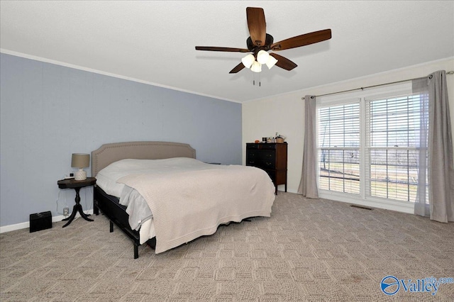 bedroom with ceiling fan, visible vents, light colored carpet, and crown molding