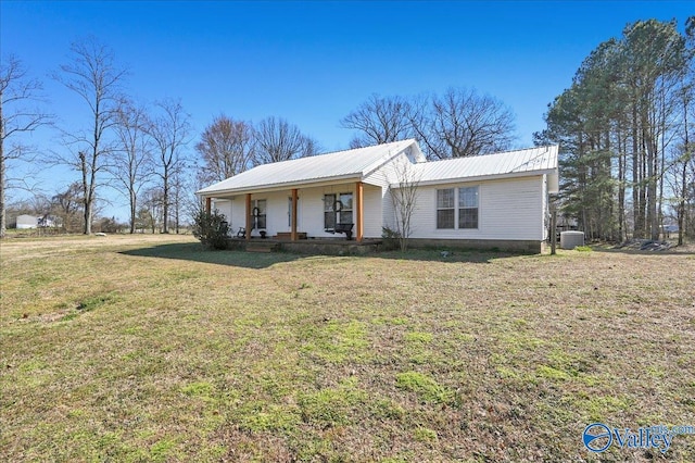 ranch-style house featuring metal roof, a porch, a front yard, and central air condition unit