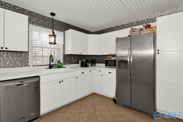 kitchen featuring light tile patterned floors, appliances with stainless steel finishes, backsplash, and a sink