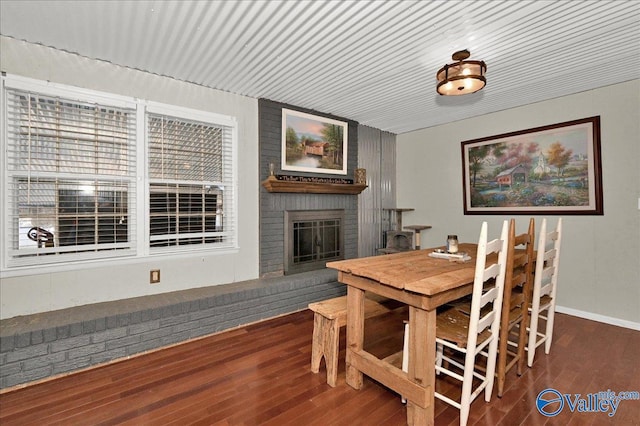 dining space featuring a fireplace and wood finished floors