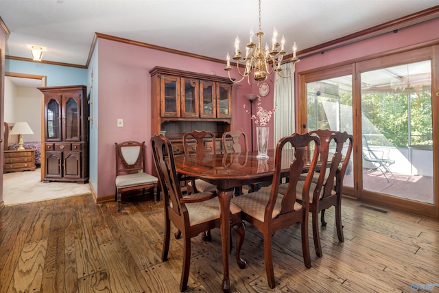 dining space with crown molding, a notable chandelier, and wood-type flooring