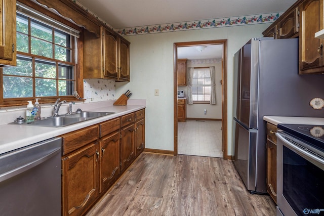 kitchen with hardwood / wood-style flooring, stainless steel appliances, and sink