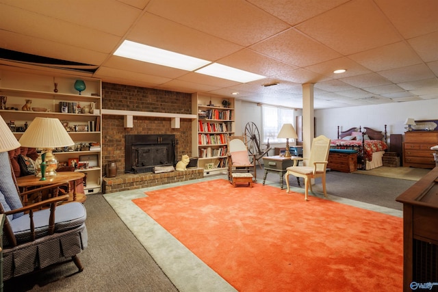 interior space featuring carpet, a paneled ceiling, and a wood stove