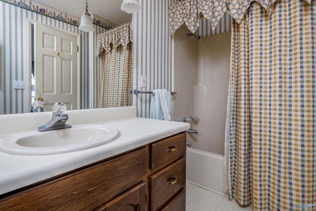 bathroom featuring vanity, shower / bath combo with shower curtain, and a textured ceiling