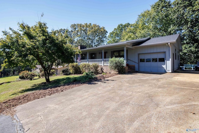 ranch-style home with a porch, a front yard, and a garage