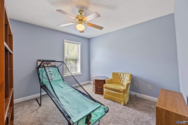 sitting room featuring light carpet, a textured ceiling, and ceiling fan