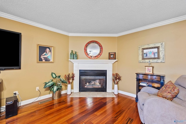 living room featuring hardwood / wood-style flooring, a multi sided fireplace, ornamental molding, and a textured ceiling