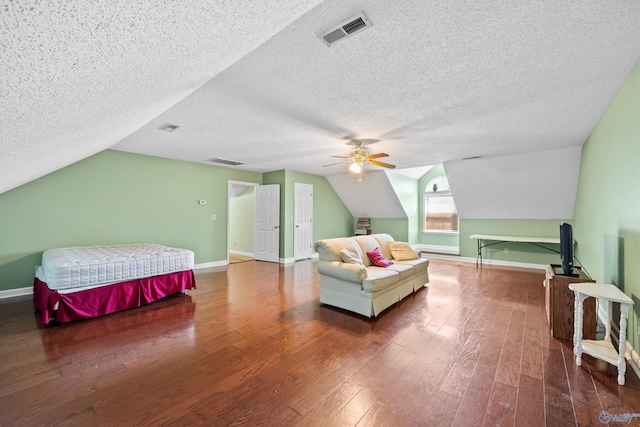 bedroom with dark wood-type flooring, ceiling fan, lofted ceiling, and a textured ceiling