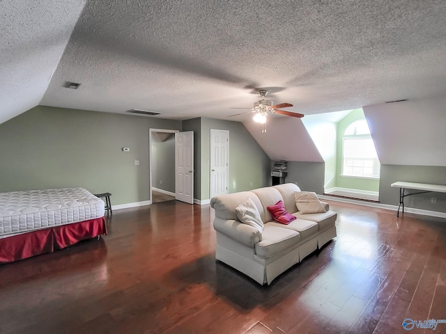 bedroom with dark wood-type flooring, ceiling fan, vaulted ceiling, and a textured ceiling