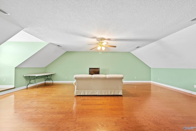 bedroom featuring lofted ceiling, a textured ceiling, and light wood-type flooring