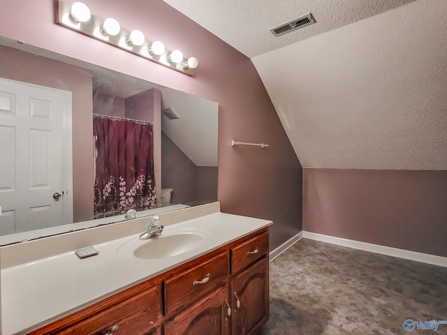 bathroom featuring vanity, lofted ceiling, toilet, and a textured ceiling